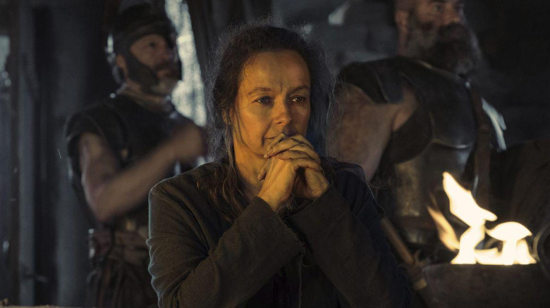 Samantha Morton as Circe standing next to some soldiers and a flame in The Odyssey (2026)