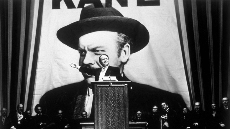 Kane stands in front of his own campaign poster