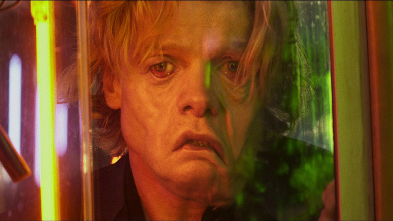 Tom Rhys Harries as Matt Hagen looking at the reflection of his melting face in Clayface