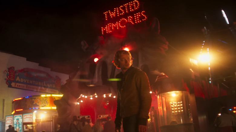 Tom Rhys Harries as Matt Hagen standing in front of AdventureLand in Gotham City in Clayface