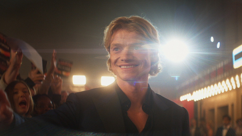 Tom Rhys Harries as Matt Hagen smiling at a movie premiere in Clayface