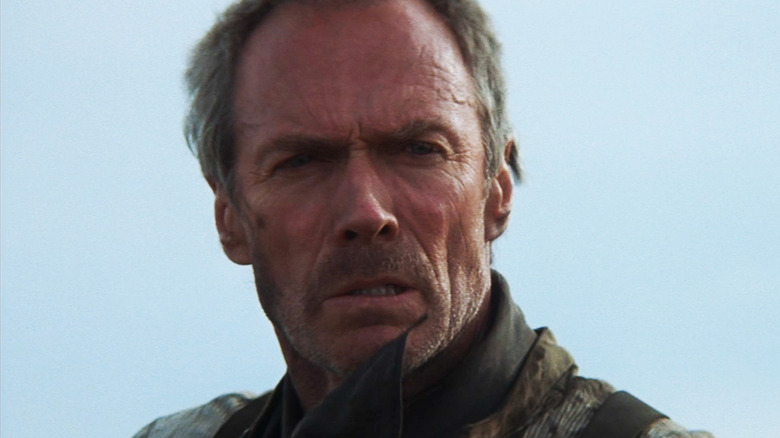 Clint Eastwood's Will Munny is seen in closeup against a blue sky in Unforgiven