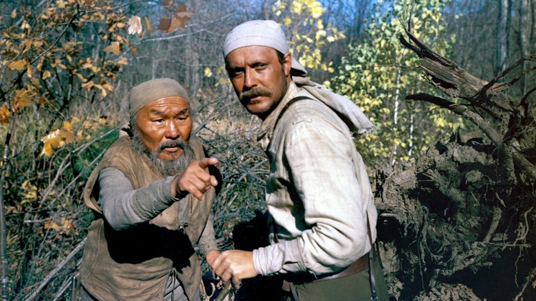 దేర్సు ఉజాలా అడవిలో ఏదో వైపు చూపిస్తూ యూరి తిరిగి దేర్సు ఉజాలా వైపు చూస్తున్నాడు