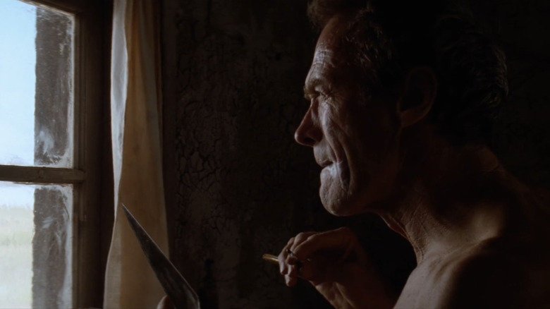 William Munny van Clint Eastwood kijkt uit zijn raam in Unforgiven