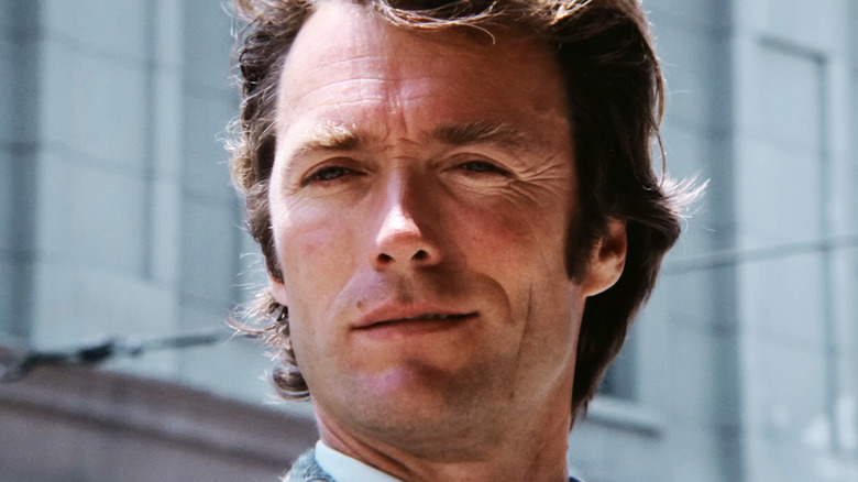 Clint Eastwood's Harry Callahan smiles in closeup as he stands on a city street in Dirty Harry
