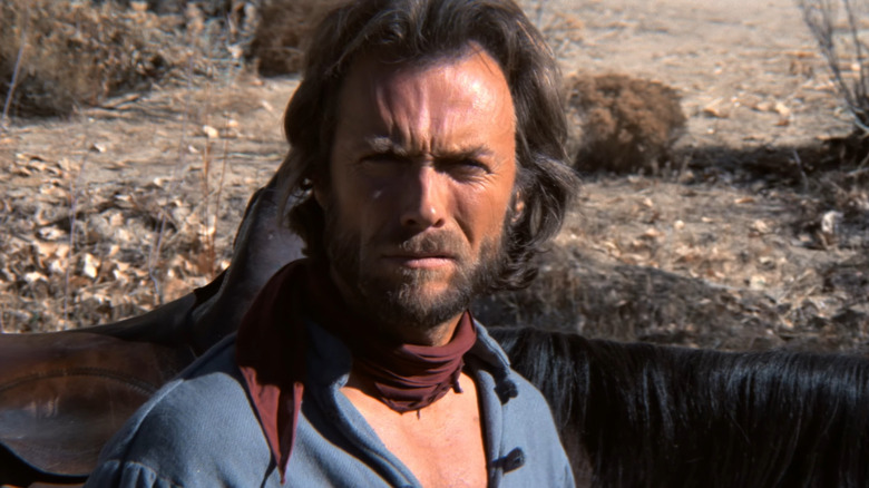 Josey Wales (Clint Eastwood) standing near his horses in The Outlaw Josey Wales