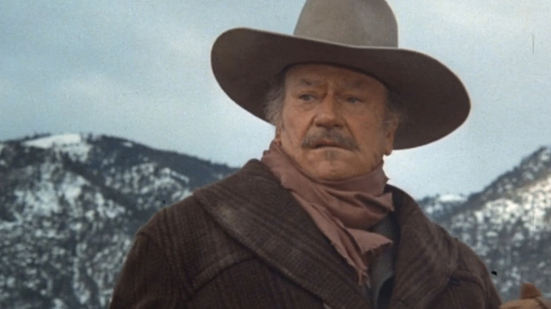 జాన్ వేన్ యొక్క JB బుక్స్ ది షూటిస్ట్‌లో పర్వత నేపథ్యానికి వ్యతిరేకంగా కనిపిస్తుంది