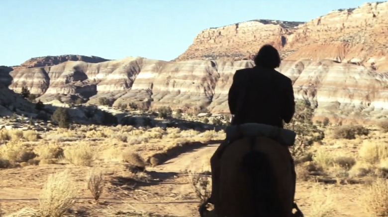 Clint Eastwood as Josey Wales is seen in silhouette as he rides a horse into the desert in The Outlaw Josey Wales