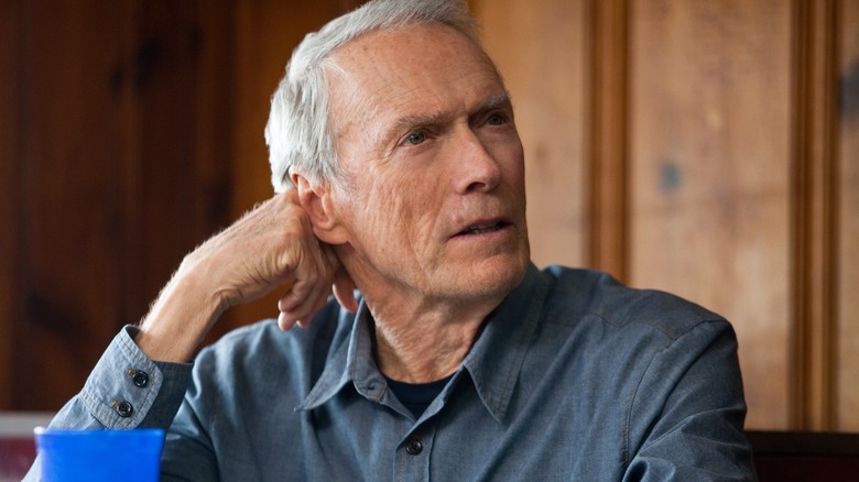 Clint Eastwood in the role of Frankie Den in a million dollars, sitting at the dinner table and looking
