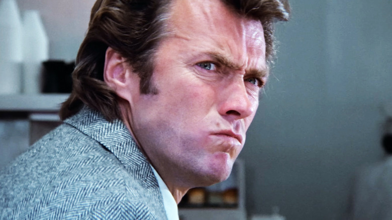 Clint Eastwood's Harry Callahan looks over to his right with a scowl as he sits in a diner in Dirty Harry