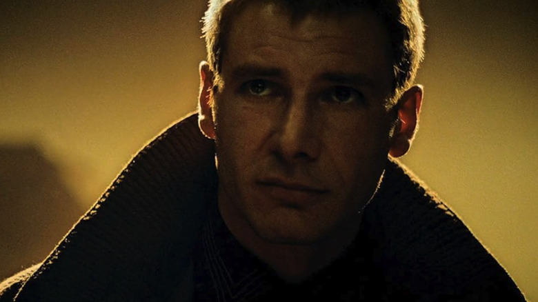 Harrison Ford's Rick Deckard looks straight ahead while bathed in yellow light in Blade Runner