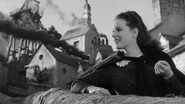 Angharad smiling at something next to a smoky building in How Green Was My Valley