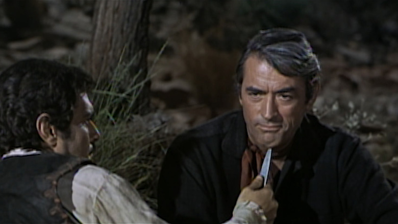 உமர் ஷெரீப்பின் ஜான் கொலராடோ, மக்கென்னாவின் தங்கத்தில் கிரிகோரி பெக்கின் மார்ஷல் சாம் மக்கென்னாவின் கழுத்தில் கத்தியைப் பிடித்துள்ளார்.