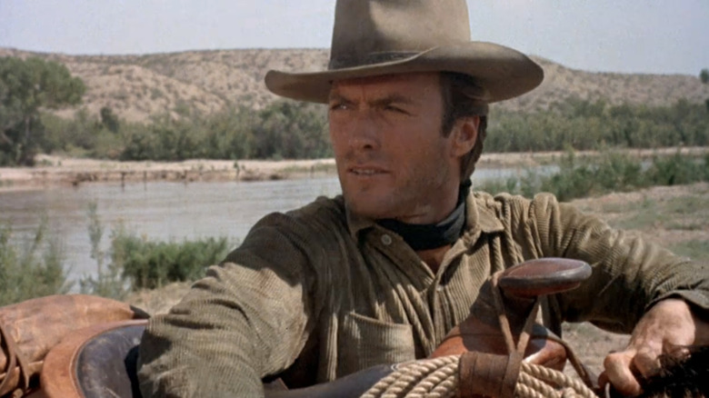 கிளின்ட் ஈஸ்ட்வுட்டின் மார்ஷல் ஜெடெடியா கூப்பர், ஹாங் எம் ஹையில் தனது குதிரையின் சேணத்தின் மீது தங்கியிருக்கும் போது அவரது வலது பக்கம் பார்க்கிறார்