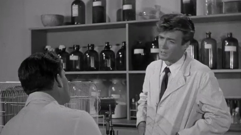 Clint Eastwood's lab technician talks to John Agar's Clete Ferguson in a lab in Revenge of the Creature