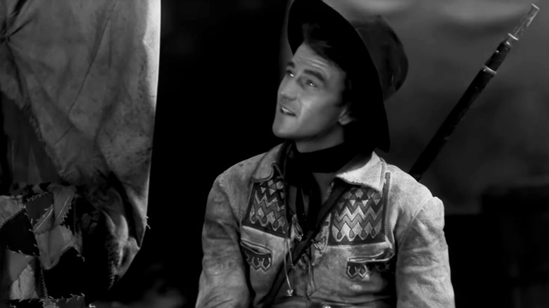 John Wayne's Breck Coleman looks up as he sits in The Big Trail