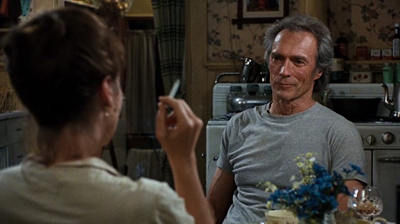 Clint Eastwood smiling across a dinner table