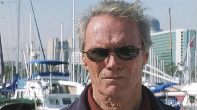 Clint Eastwood scowls in a marina while wearing shades as Terry McCaleb in Blood Work