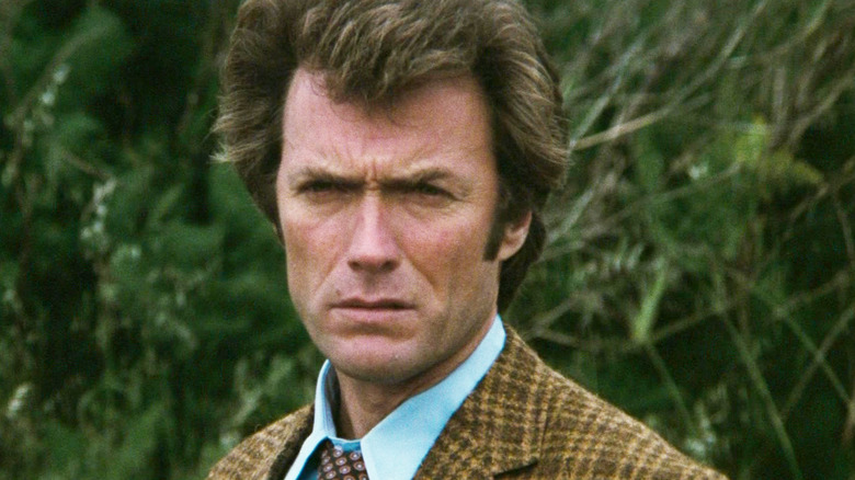 Clint Eastwood's Harry Callahan stands in front of some shrubbery in Dirty Harry