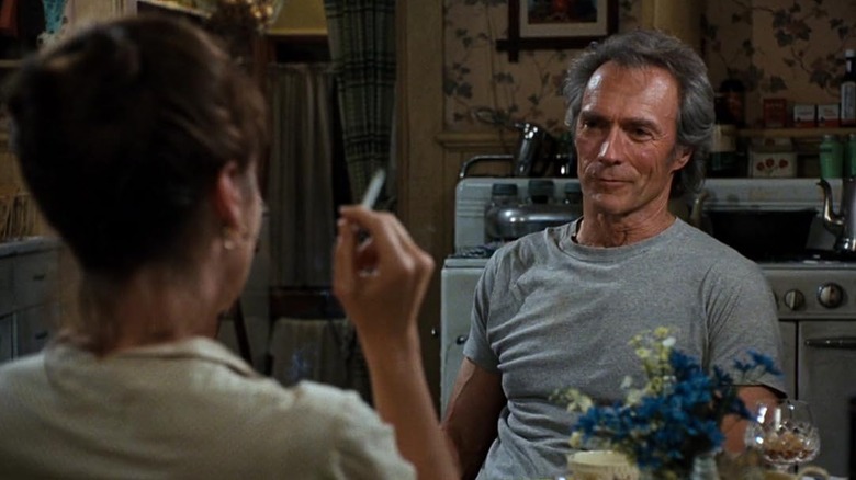 Clint Eastwood smiling across a dinner table