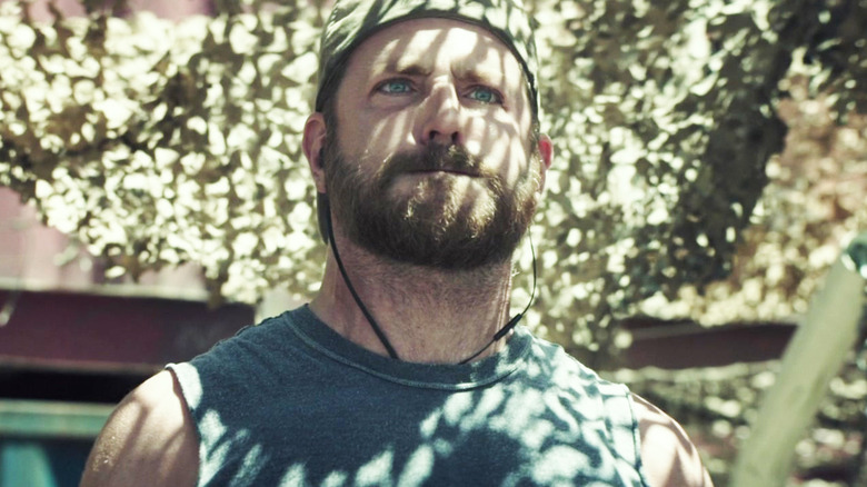 Bradley Cooper's Chris Kyle strains as he stands beneath an army net in American Sniper