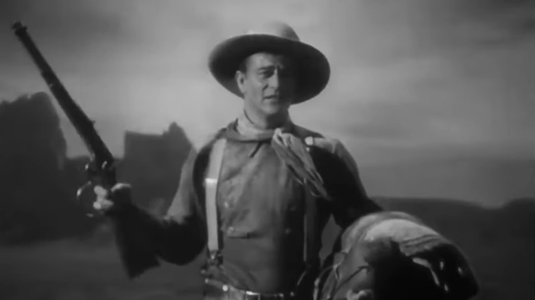 John Wayne's Henry, the Ringo Kid holds his rifle as he sits on a horse in Stagecoach