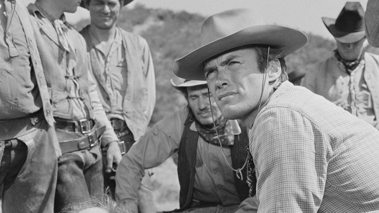 Rowdy Yates sitting with several other cowboys on Rawhide