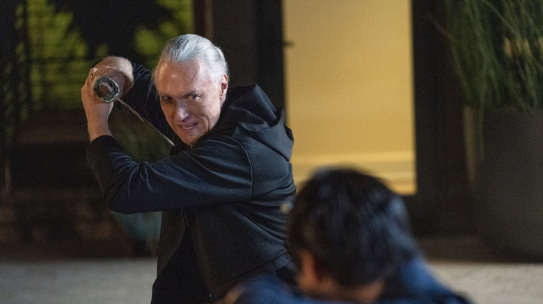 Terry Silver grimacing and brandishing a katana at Chozen Toguchi in Cobra Kai