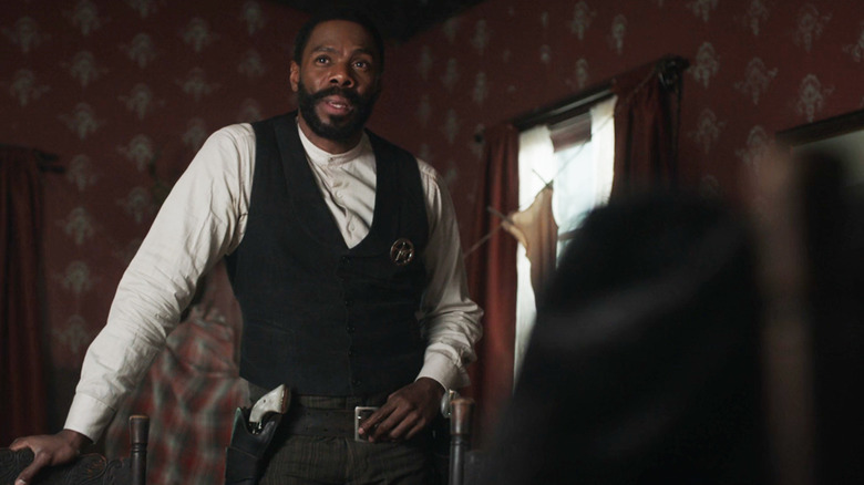 Colman Domingo's Bass Reeves stands in his living room in Timeless