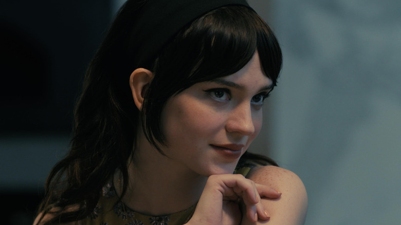 Sophie Thather as Iris sitting at the dinner table with the gang in Companion