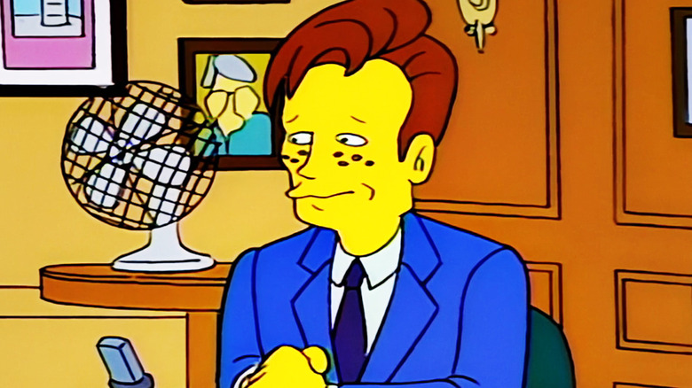 Conan O'Brien is seen sitting at his Late Night desk in The Simpsons