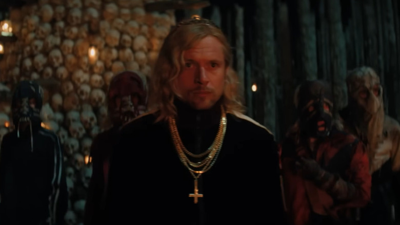 Jack O'Connell as Jimmy Crystal standing in front of the bone shrine with his band of Jimmys in 28 Years Later: The Bone Temple