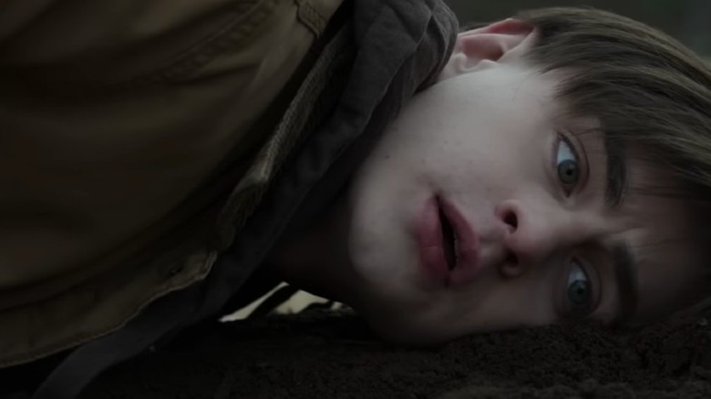 Jaeden Martell resting head on grave