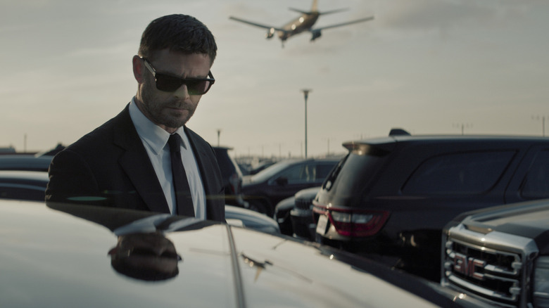Mike at the airport wearing sunglasses in Crime 101