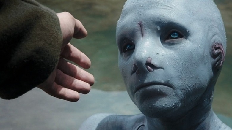 hand reaching out to blue creature