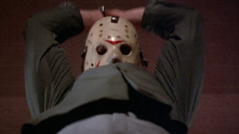 Jason Voorhees holding a machete over his head getting ready to kill in Friday the 13th Part III