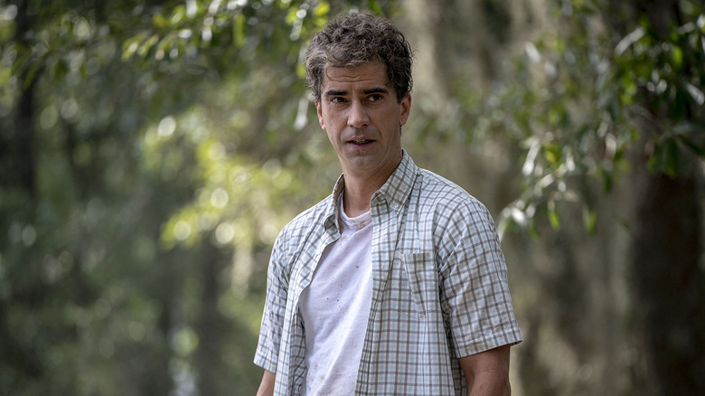 Hamish Linklater as John standing by trees in Tell Me Your Secrets