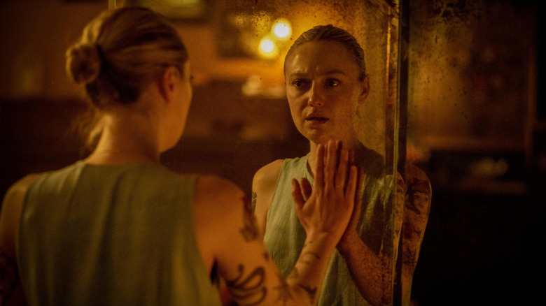 Dakota Fanning as Polly looking at herself in the mirror in Vicious