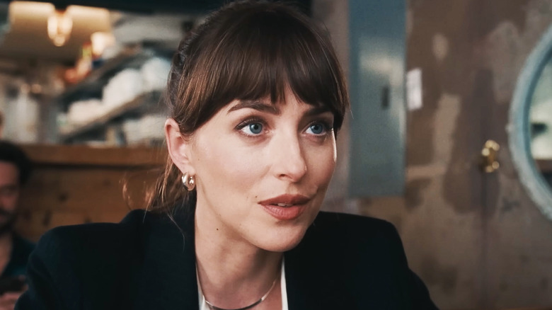 Dakota Johnson's Lucy Mason is seen in closeup as she sits in a restaurant in Materialists