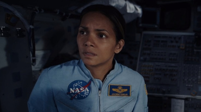 Halle Berry looking concerned in blue NASA spacesuit