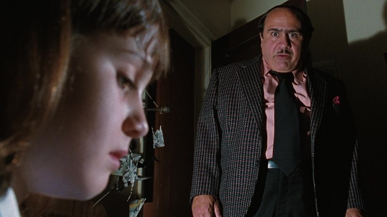 Danny DeVito as Harry Wormwood shoots a sinister stare at Mara Wilson as Matilda Wormwood in Matilda