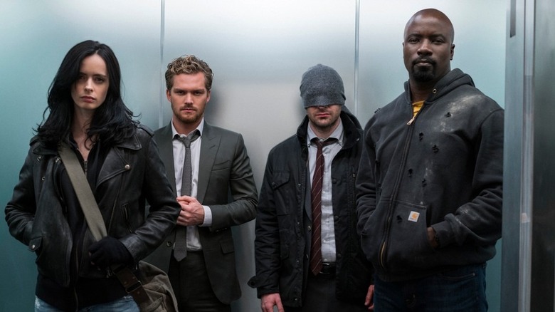 Jessica Jones (Krysten Ritter), Danny Rand (Finn Jones), Matt Murdock (Charlie Cox), and Luke Cage (Mike Colter) standing in an elevator in The Defenders