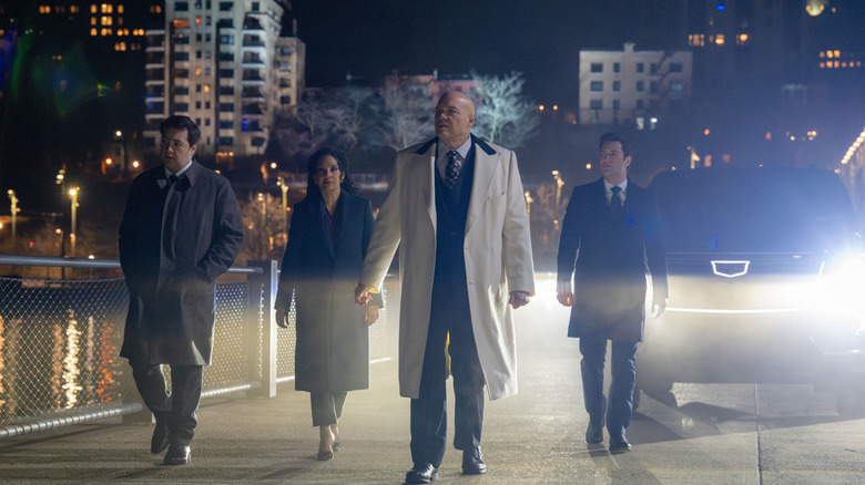 Michael Gandolfini as Daniel Blake, Zabryna Guevera as Sheila Rivera, Vincent D'Onofrio as Wilson Fisk, and Arty Froushan as Buck Cashman walking down a New York City street next to the East River in Daredevil: Born Again