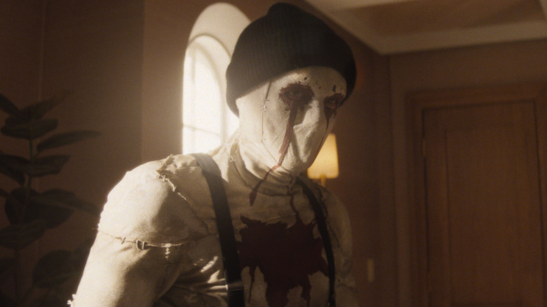 Hunter Doohan as Muse wearing a creepy mask and ski cap in an office in Daredevil: Born Again Season 1