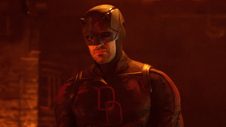 Charlie Cox as Matt Murdock in his superhero outfit while bathed in orange light in Daredevil: Born Again