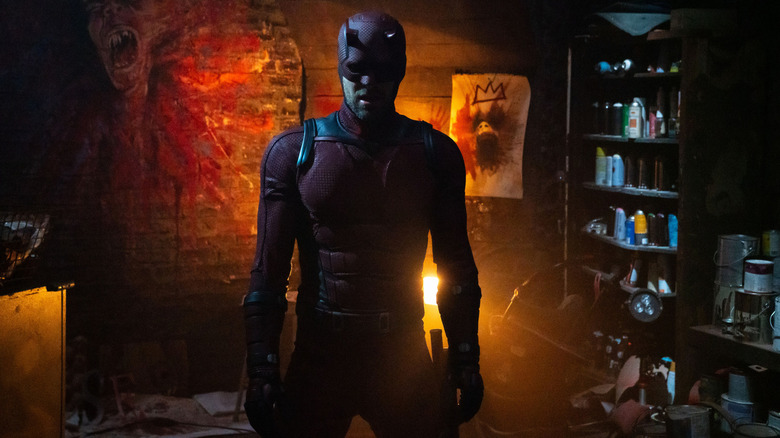 Charlie Cox as Daredevil standing in Muse's headquarters