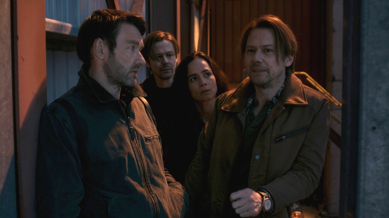 Joel Edgerton as "Jason2" standing in an alleyway next to Jimmi Simpson as two versions of Ryan Holder and Alice Braga as Amanda Lucas in Dark Matter