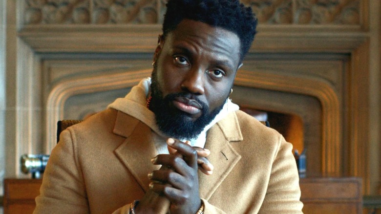 Dayo Okeniyi as Leighton Vance wearing a peacoat and folding his hands in an expensive-looking dining room in Dark Matter