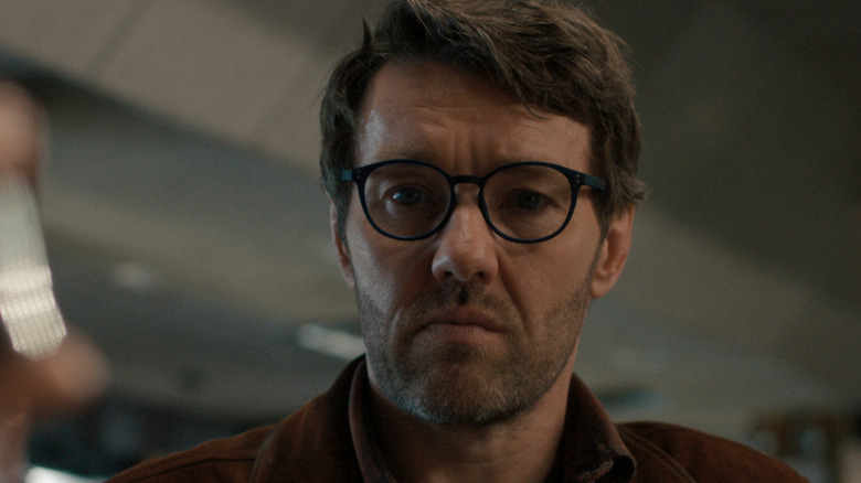 Joel Edgerton as Jason Dessen seated at a bar and wearing glasses in Dark Matter