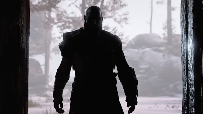 Kratos stands silhouetted in a doorway in God of War